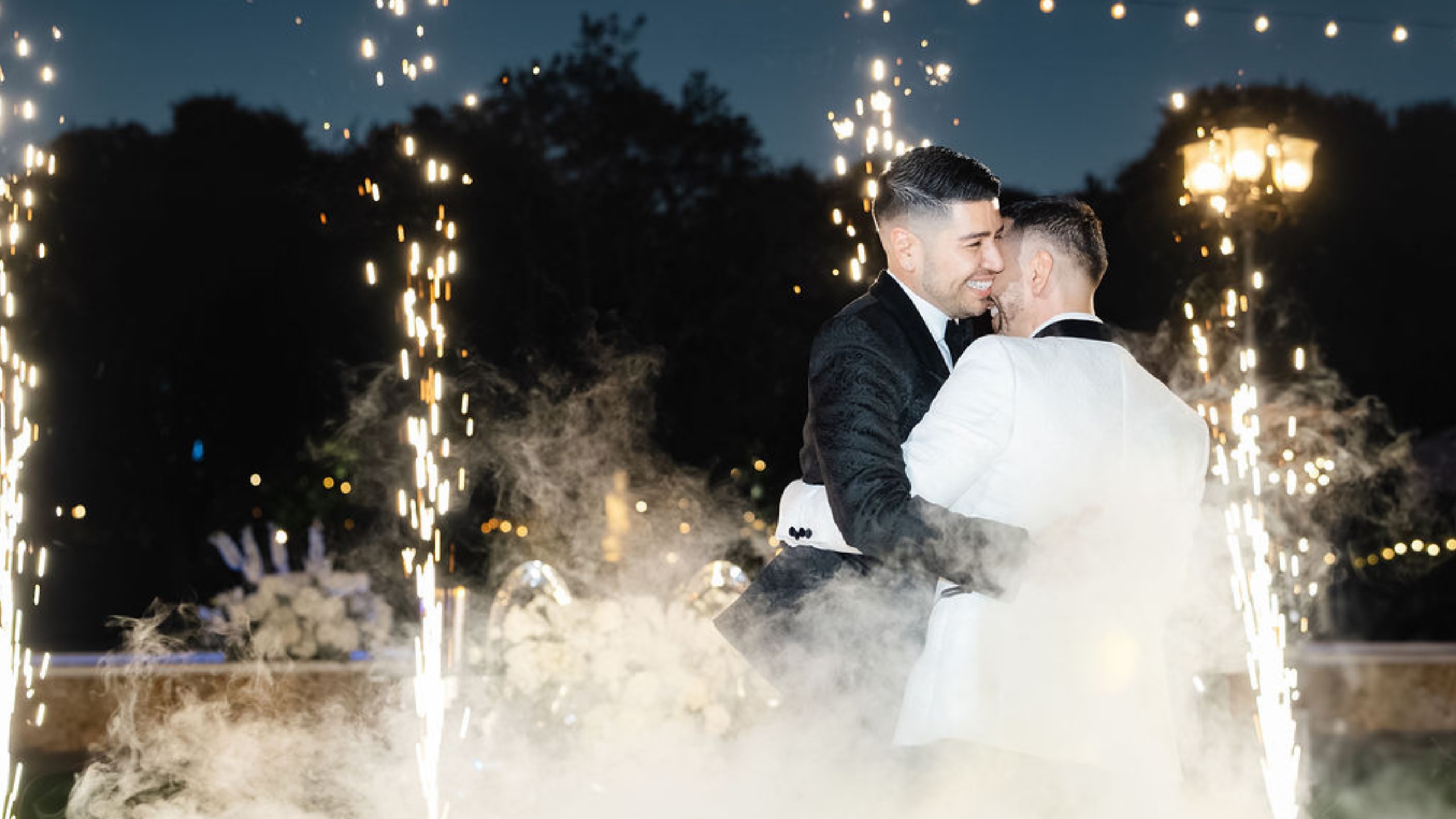 LGBTQ+ newlyweds celebrating their first dance on the clouds and with cold spark machines